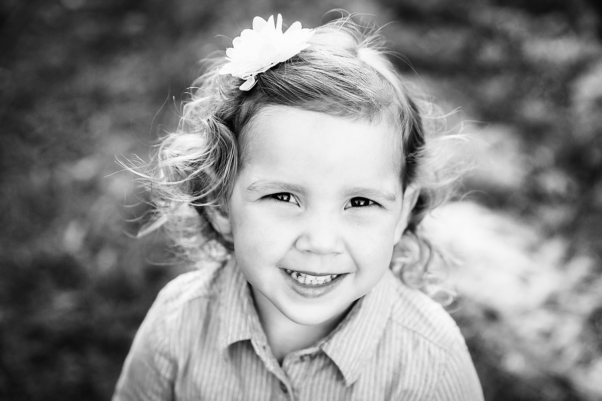 little girl smiling at the camera in the vineyards by deb elton photography