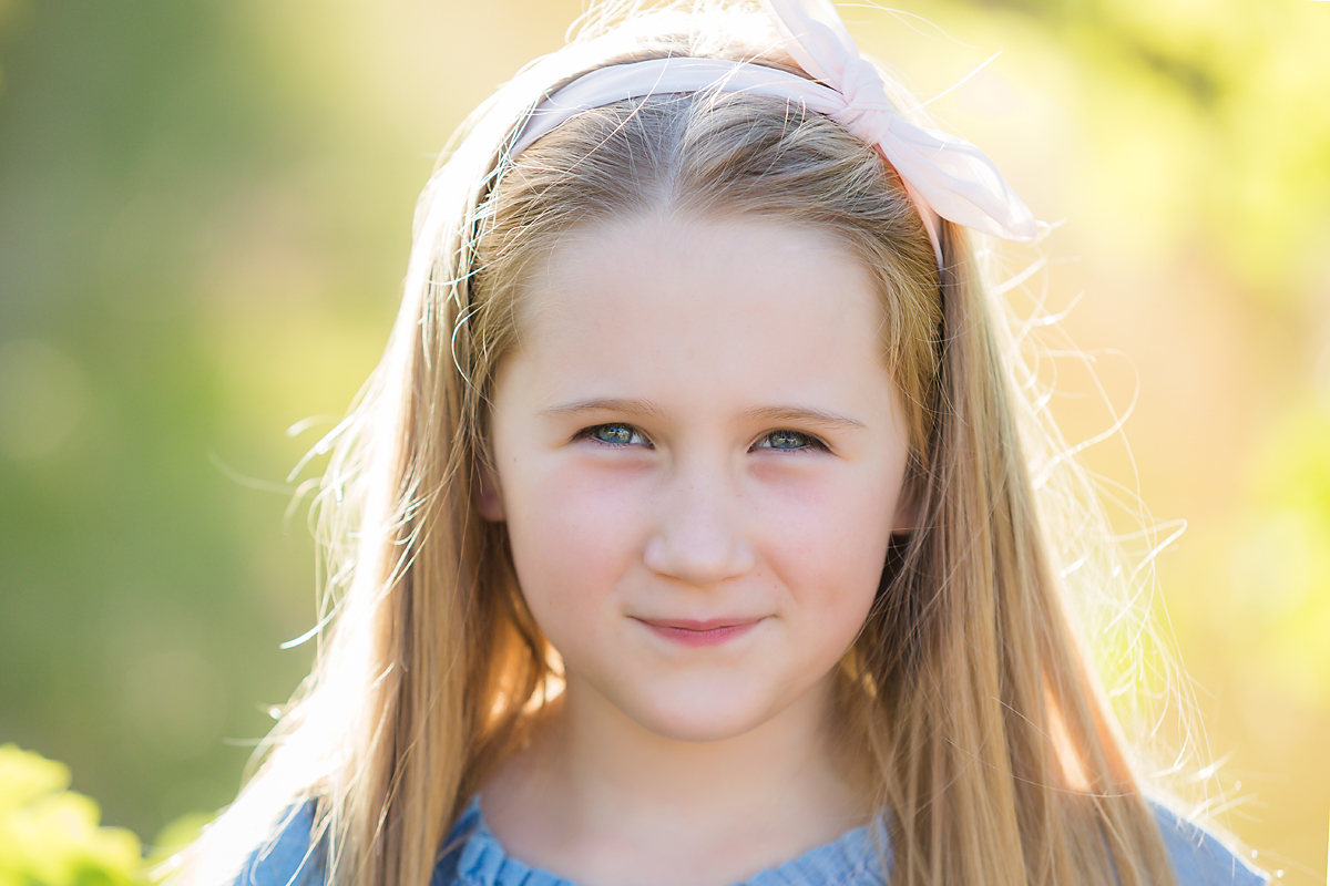 girl smiling and posing for family photos by deb elton photography